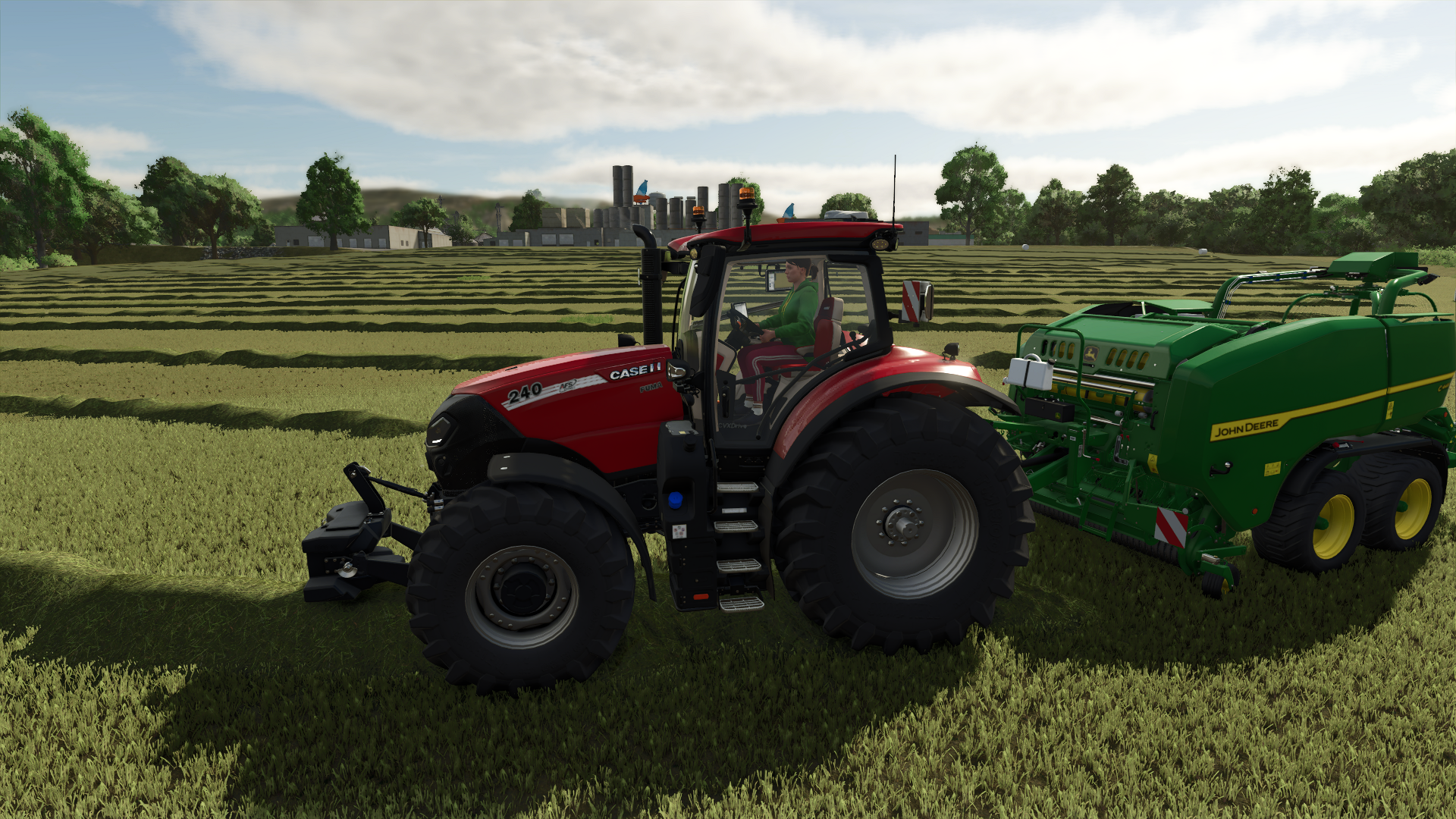 Tractor and a bailer bailing a field of grass